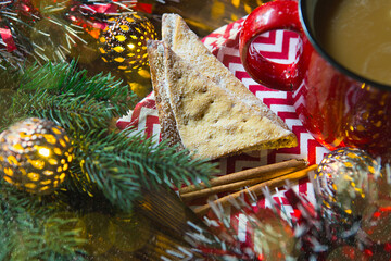 Triangular cookies with powdered sugar and cinnamon on a napkin with a zigzag pattern in the...