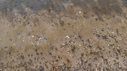 Lake shore sand and stones under the water . High quality photo