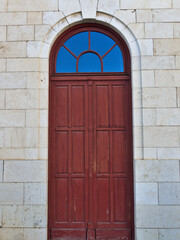 Old red wooden door on marble wall background at historical building