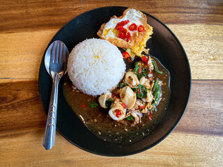 Rice topped with stir-fried squid and basil with fried egg