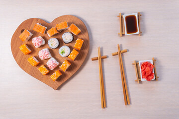 valentines day. Rolls stacked, soy sauce and sticks