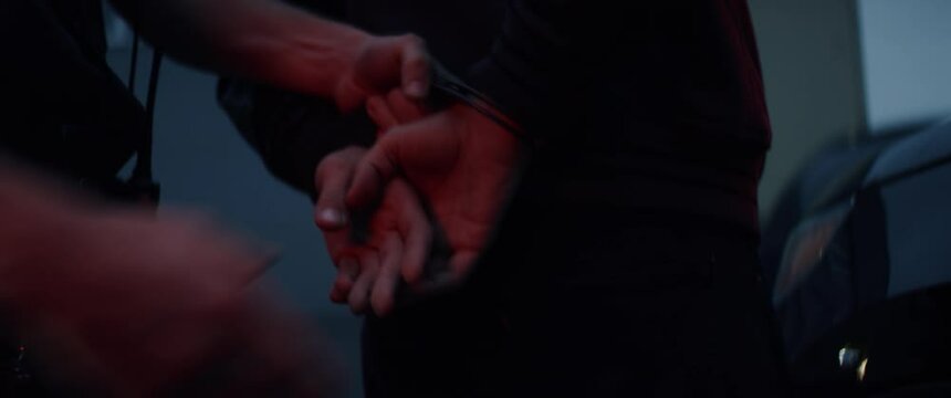 CU on hands, man being handcuffed near unmarked police vehicle in the street. Shot on RED Dragon with 2x Anamorphic lens