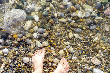 Sea washes men fest standing on a pebble beach. with space for copying text