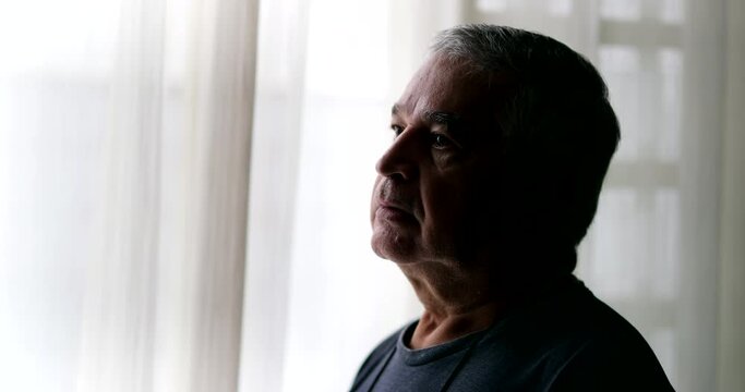 senior man thinking by window. Profile older pensive person