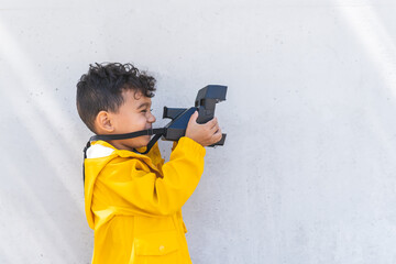 Child Boy Using Instant Camera Outdoors.