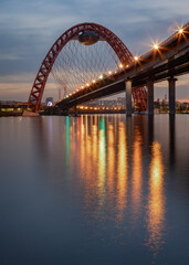 Photo of evening lights on a picturesque bridge, reflected in the Moscow river.