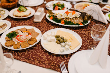 The holiday table cheese, meat, salads. Served table with food. Festive table. Table at restaurant before starting to celebrate.