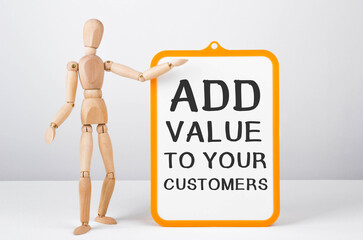 Wooden man shows with a hand to white board with text Add value to your customers