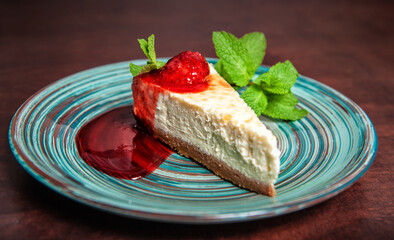 Slice of fresh delicious cheesecake with strawberry and leaf of mint