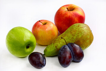 Composition of red and green apples, pears, plums on a white background
