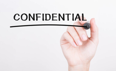 Hand writing Confidential with black marker on transparent wipe board