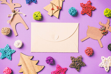 Top view of craft envelope. New Year decorations on purple background. Festive stars and balls. Merry Christmas concept