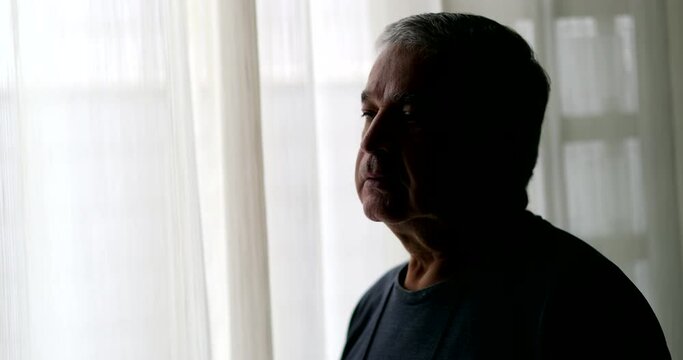 Dramatic serious older man standing alone in room