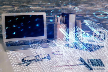 Desktop computer background in office and big town buildings hologram drawing. Double exposure. Smart city concept.