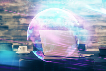 Computer on desktop in office with technology theme hologram. Double exposure. Tech concept.