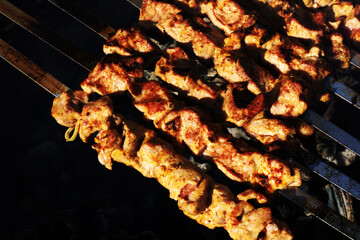 Cooking kebabs on charcoal. Roasted meat on metal skewers. View from above