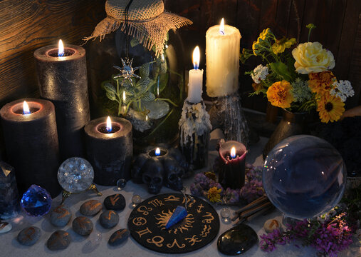 Mysterious still life with black candles, runes and zodiac chart on witch table.