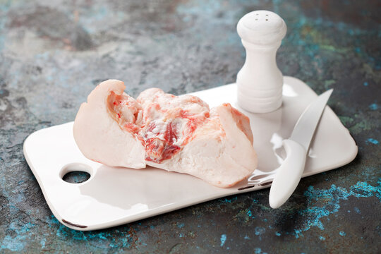 Raw lamb tail fat on a cutting board, selective focus