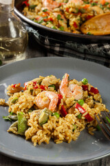 Traditional seafood paella with shrimp, fish and chicken seved in plate.