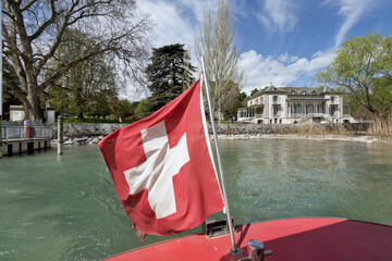 stern and swiss flag of the famous yellow boats on the lake in Geneva, Switzerland