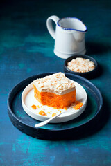 Homemade raw carrot cake slice with candied orange and coconut cream, selective focus