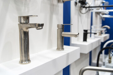 Lots of water taps. Sale of chrome bathtub taps in a plumbing shop.
