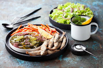 Fried fish capelin, assorted seaweed salad and sweet potato fries, selective focus