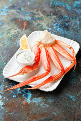 Crab leg with tartar sauce and lemon, selective focus