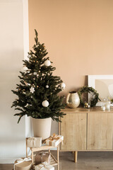 Beautiful Christmas tree with toys, baubles and homemade paper gift boxes. Living room decorated for Christmas / New Year celebration.