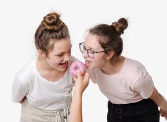 Two girls eat sweet donut and smile, Studio portrait on white background