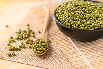 Mung bean in a bowl and spoon on wooden background