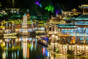 Fototapeta na wymiar Beautiful night scenery of Fenghuang (Phoenix) ancient town, Hunan province, China. Cityscape at night with reflection light in the river.
