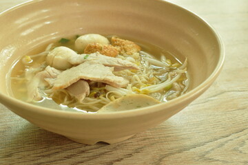 Chinese egg yellow noodles topping slice boiled pork and ball with soup in bowl