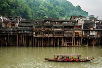Boat in river take tourists to sightseeing the beautiful Fenghuang ancient town in the morning,...