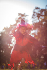 Fototapeta na wymiar Little girl in Halloween suit running trough park.
