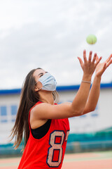 Portrait of tennis player girl holding racket outside with protective masks