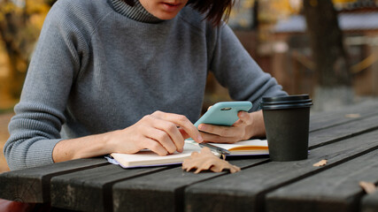 woman making notes while sitting on the veranda in autumn