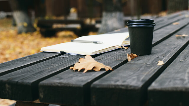 notepad and cup of coffee on an old wooden table, background image