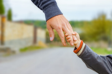 A beautiful hands of parent and child outdoors in the park