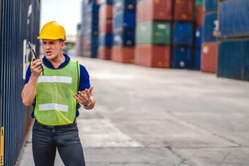 Professional engineer container cargo foreman in helmets working standing and using walkie talkie checking stock into container for loading.logistic and business export