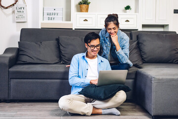 Young asian couple relaxing using laptop computer working and video conference meeting online...