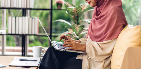 Young smiling beautiful muslim woman relaxing using laptop computer working and video conference meeting at home.work from home concept