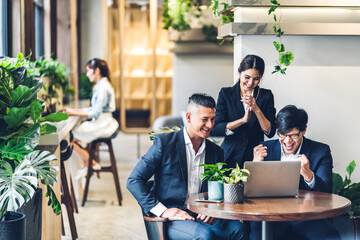 Group of professional business discussing meeting strategy sharing ideas thoughts with project.Creative business people working with laptop computer in green plant terrace decorated modern workloft