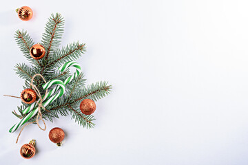 Christmas composition, spruce branches, Christmas toys, green lollipops sticks on white background, copy space