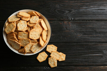 Fototapeta na wymiar Delicious crackers on black wooden table, flat lay. Space for text
