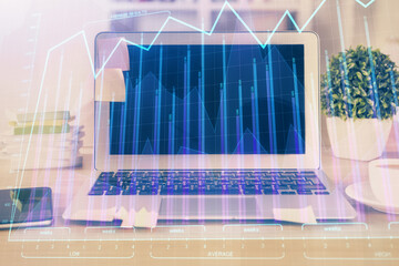 Financial graph colorful drawing and table with computer on background. Multi exposure. Concept of international markets.