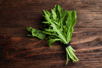 Fresh arugula on wooden table, top view