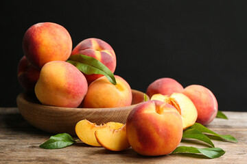 Fototapeta na wymiar Fresh sweet peaches on wooden table against black background