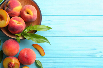 Fresh sweet peaches on turquoise wooden table, flat lay. Space for text