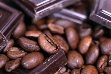 Close-up of dark roasted coffee beans and chocolate background.